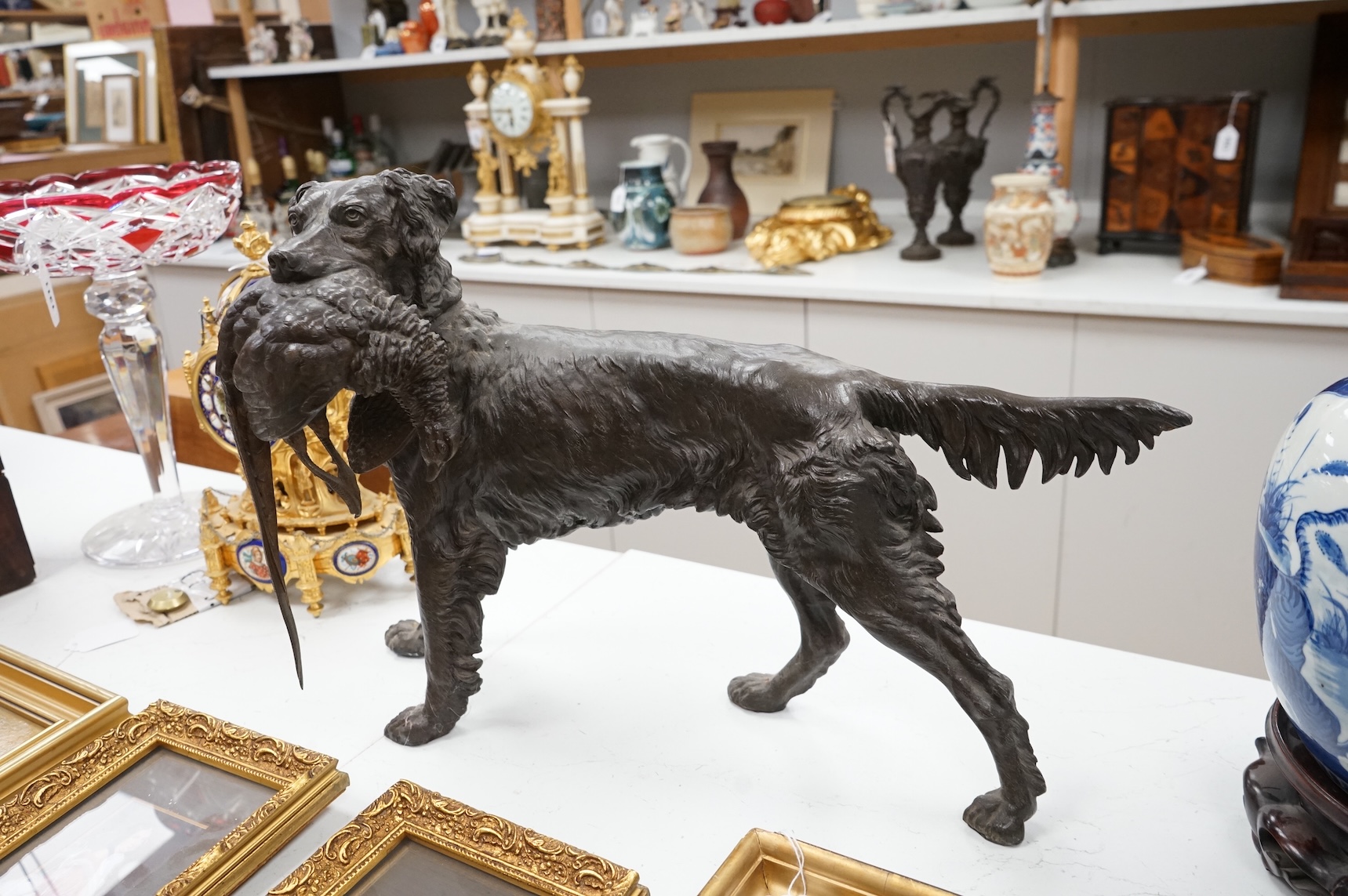 A large bronzed metal study of a retriever and pheasant, 56cm wide